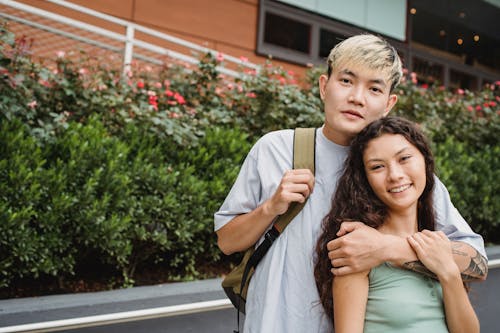 Content multiethnic couple hugging on street