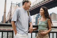 一对多种族夫妇在阴天里站在城市的运河和吊桥旁