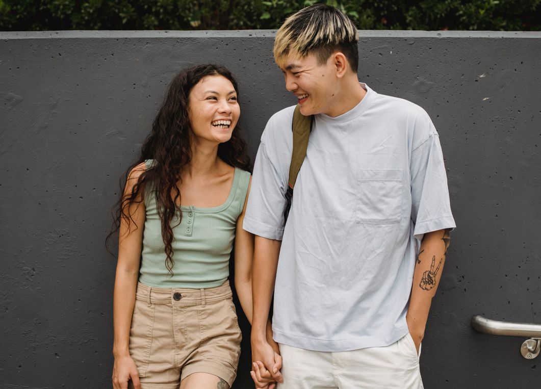 couple laughing while walking through farm field
