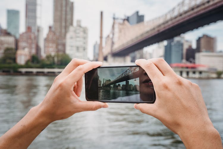 Anonymous Person Photographing City With Smartphone