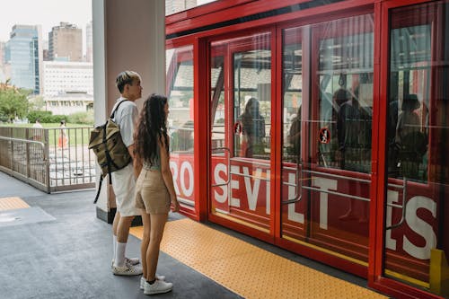 Anonymous multiethnic couple waiting for cable car on platform