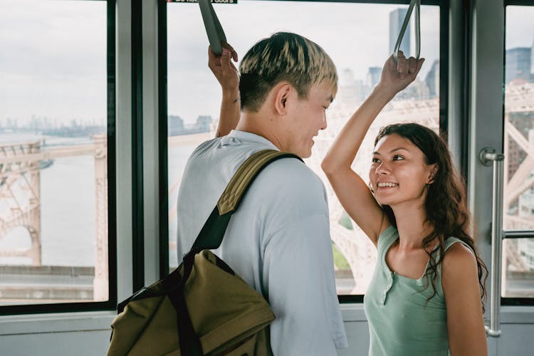 Happy Diverse Couple Of Tourists Talking In Cable Car