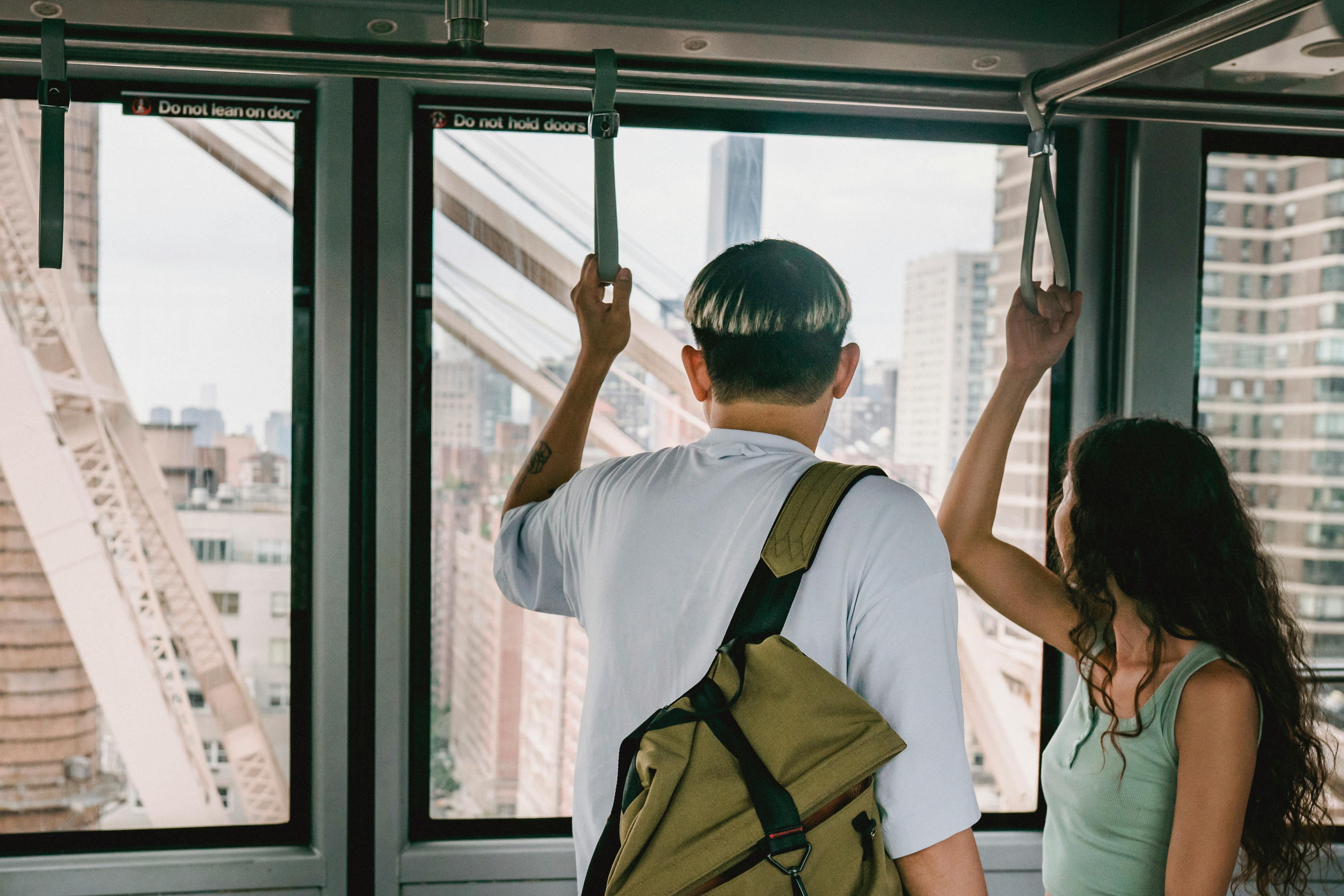 unrecognizable couple riding public train in urban city