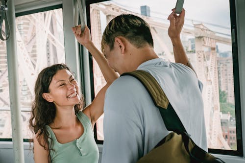 Cheerful couple riding cableway and laughing