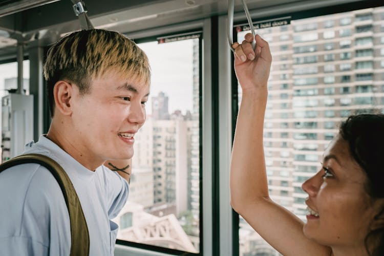 Happy Asian Couple Riding Ropeway Cabin In Modern City