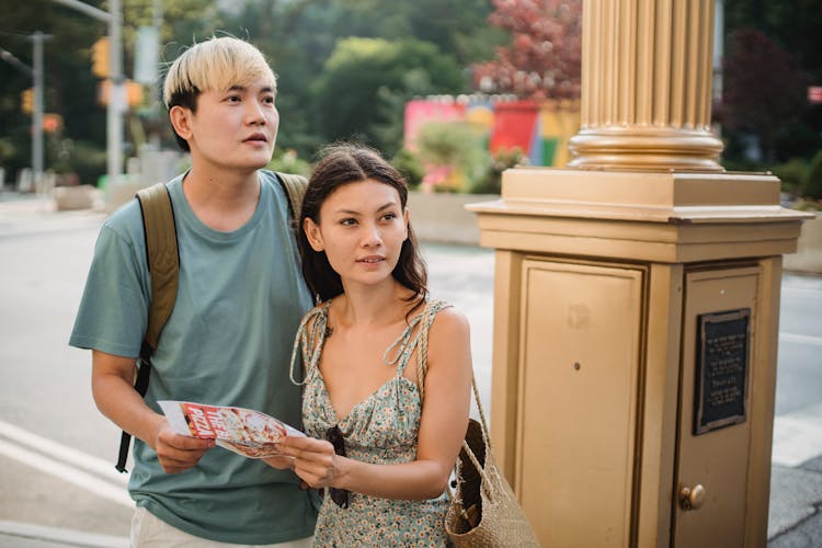 Cheerful Asian Couple With Map Navigating In City