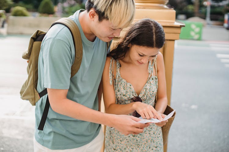 Happy Asian Couple Checking Location On Map