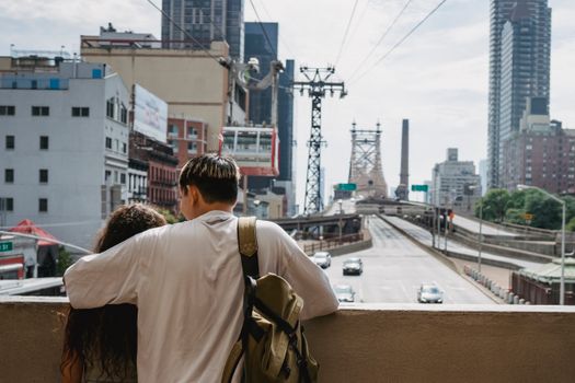 一对夫妇在纽约市皇后区大桥欣赏景色时相拥，象征着这座城市的热爱与探索精神