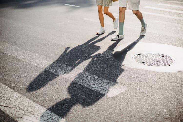 Young Couple Crossing Road On Crosswalk