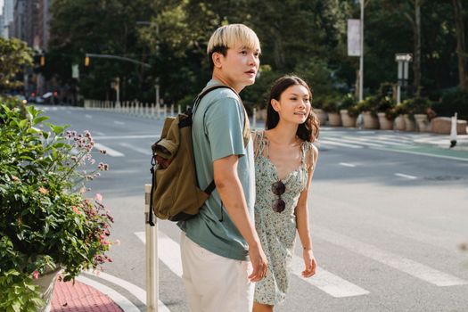 一对年轻夫妇在一个阳光明媚的夏日，一起穿过城市街道
