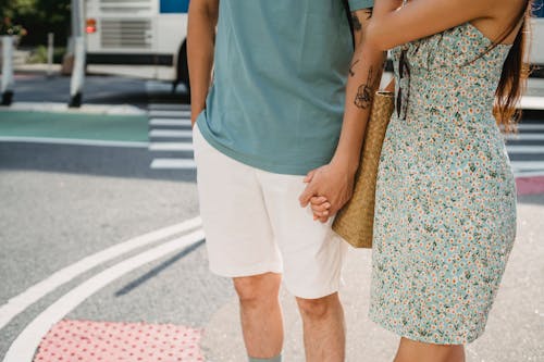 Couple holding hands while standing on sidewalk