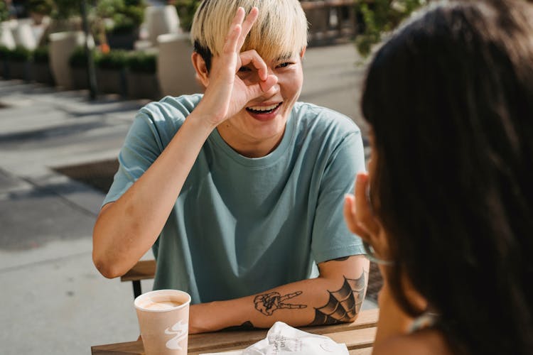 Smiling Asian Man Showing Ok Gesture To Girlfriend