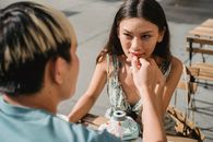 在街头咖啡馆的餐桌上，一位染着头发的匿名男子轻抚着心爱女子的手，两人相视而望