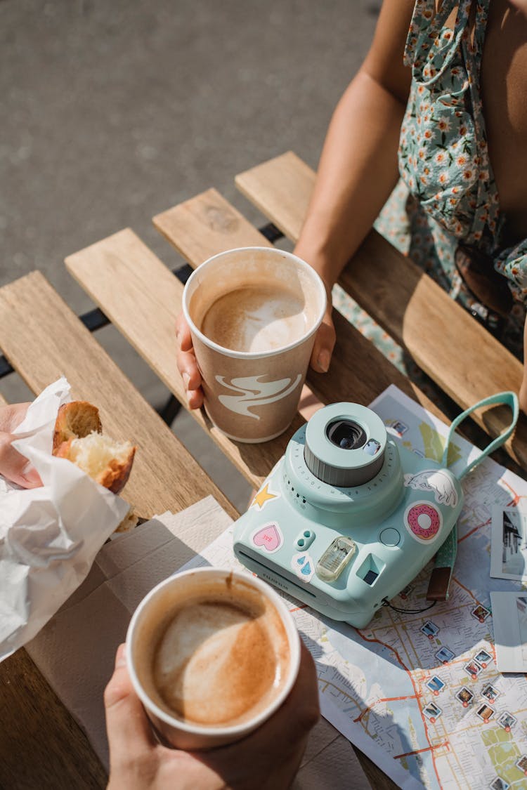 Faceless Couple With Disposable Glasses Of Cappuccino In Street Cafe