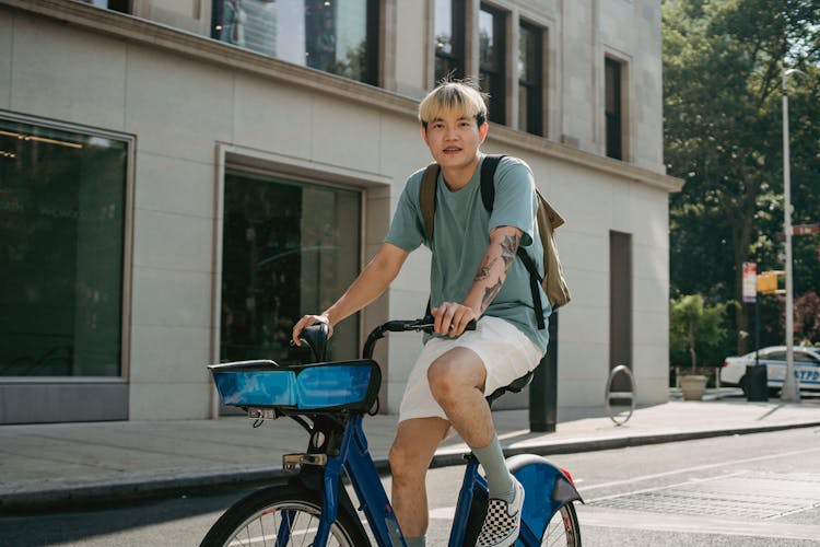 Young Asian Man With Tattoo Riding Bicycle