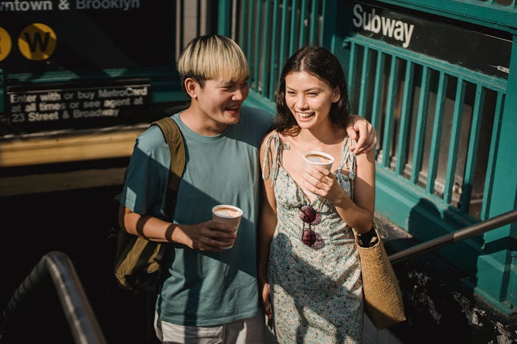 Delighted Young Diverse Friends Walking With Cup Of Coffee