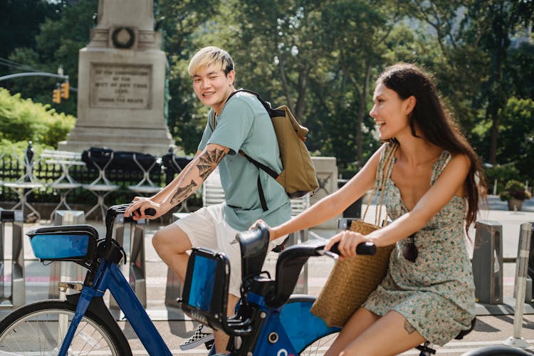 Positive Multiracial Couple Riding Bicycles And Laughing