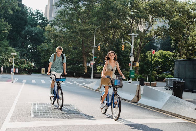 Cheerful Couple Riding Bicycles On Empty Street