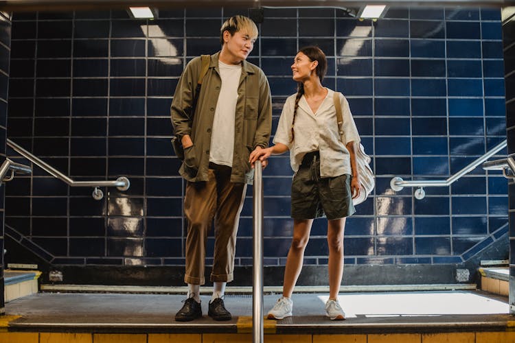 Asian Couple Standing Near Railing In Underground Passage