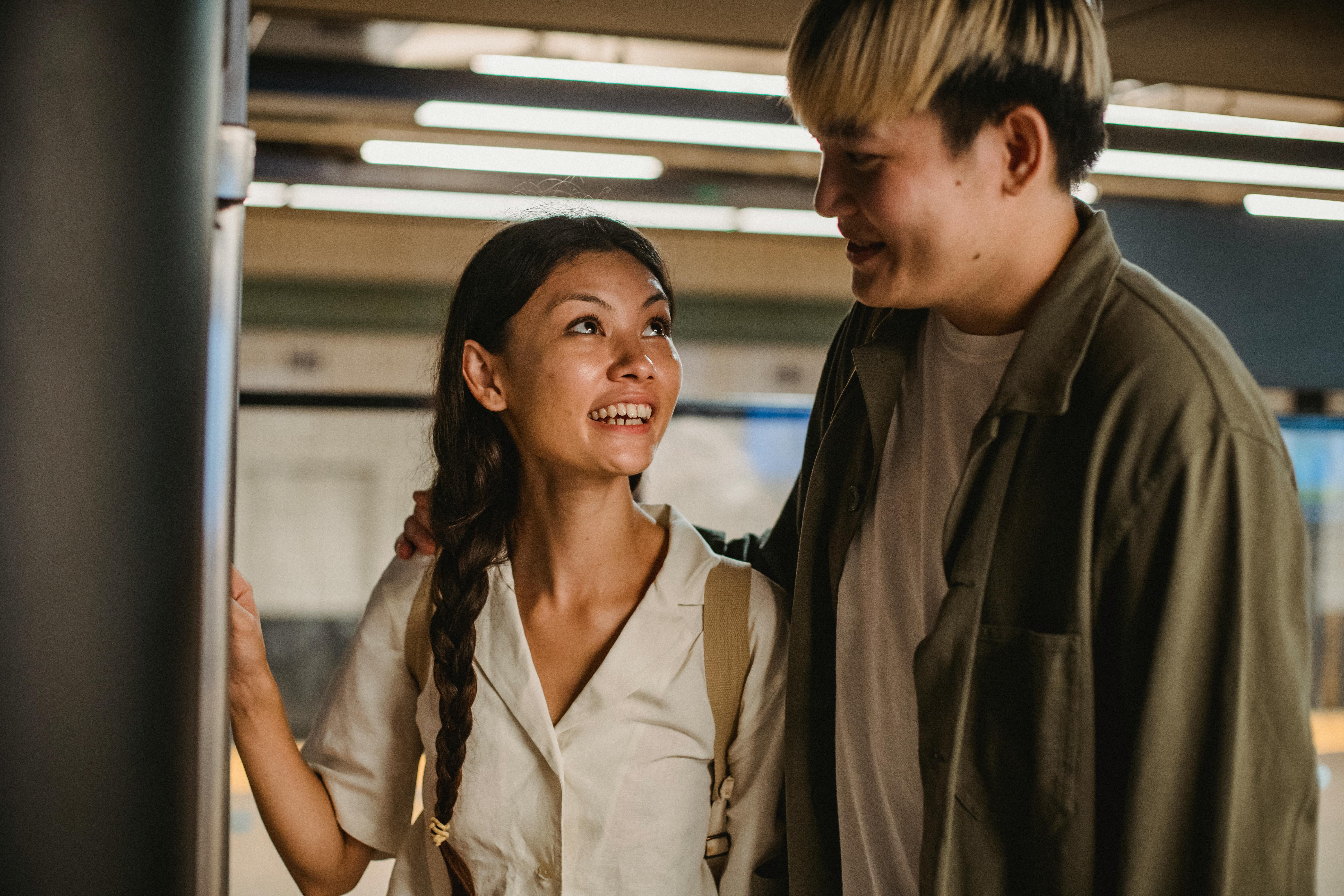 Free Happy smiling Asian couple hugging and standing together in underground passage and looking at each other Stock Photo