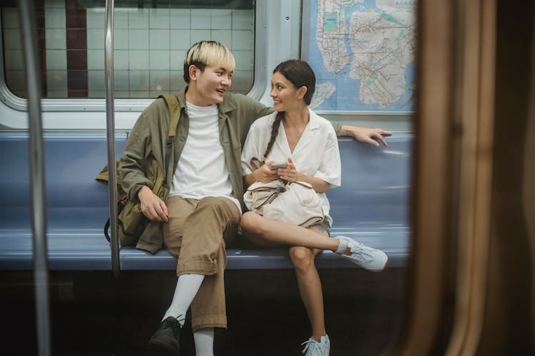 Happy Young Ethnic Couple Sitting In Train And Talking