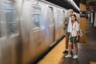 Young trendy ethnic passengers waiting for train on platform