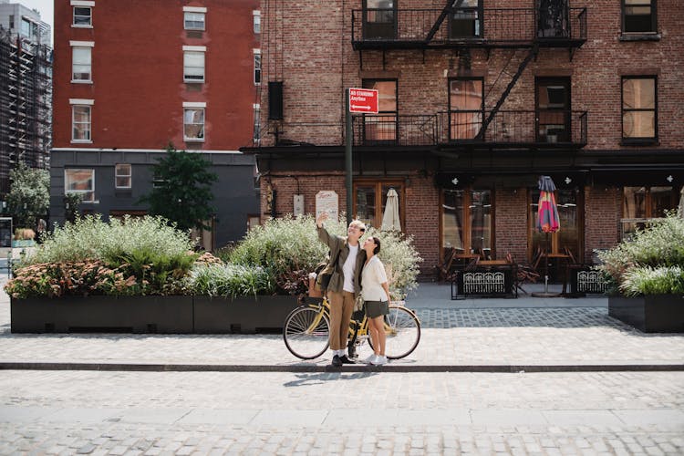 Cheerful Stylish Young Couple Taking Selfie Near Old Buildings On City Street