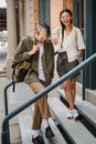 一对穿着时尚的幸福少数族裔夫妇，站在城市街道现代建筑的楼梯上，笑着看向镜头