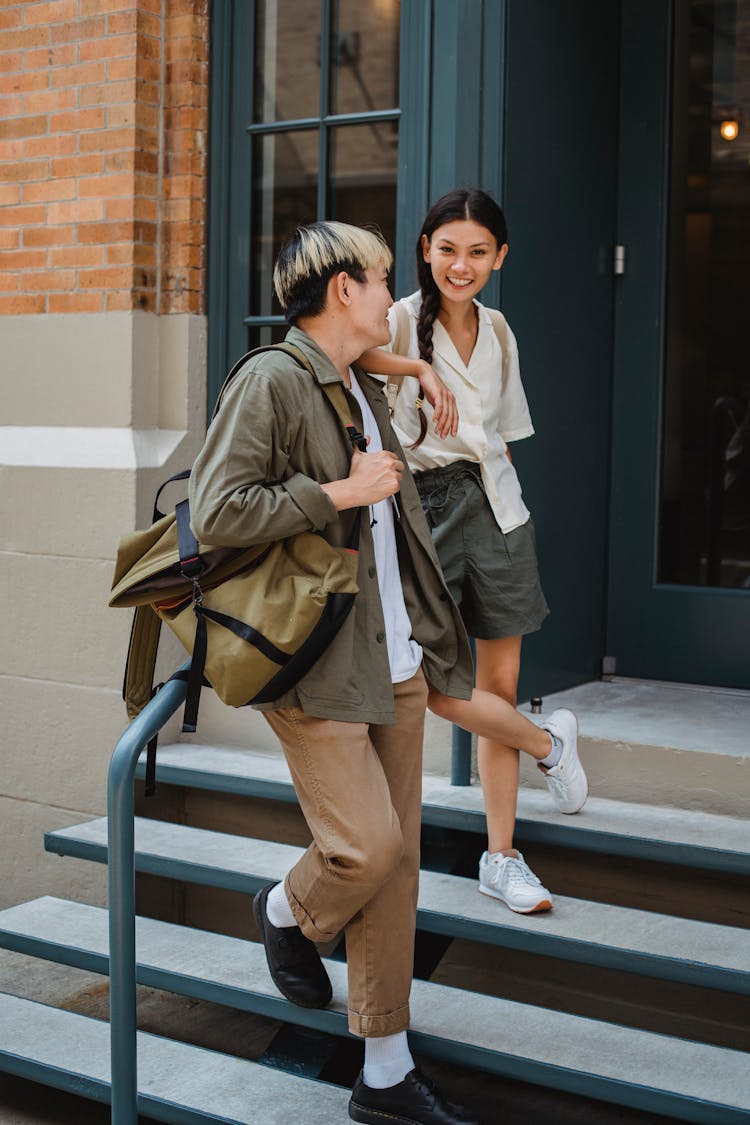 Trendy Asian Couple Chilling On Building Stairs On Street