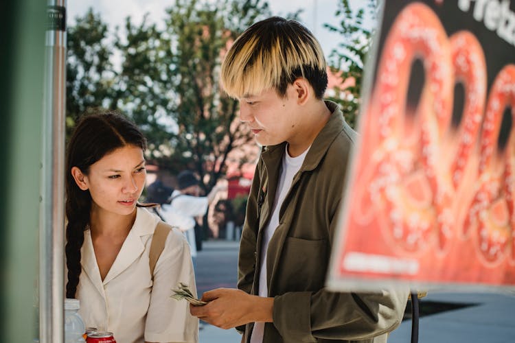 Young Asian Couple Choosing Food In Street Cafe