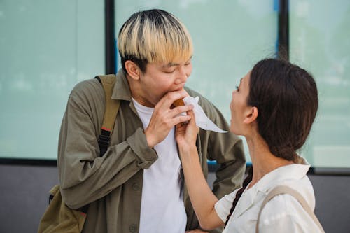 Free Asian woman hand feeding boyfriend with hot dog Stock Photo