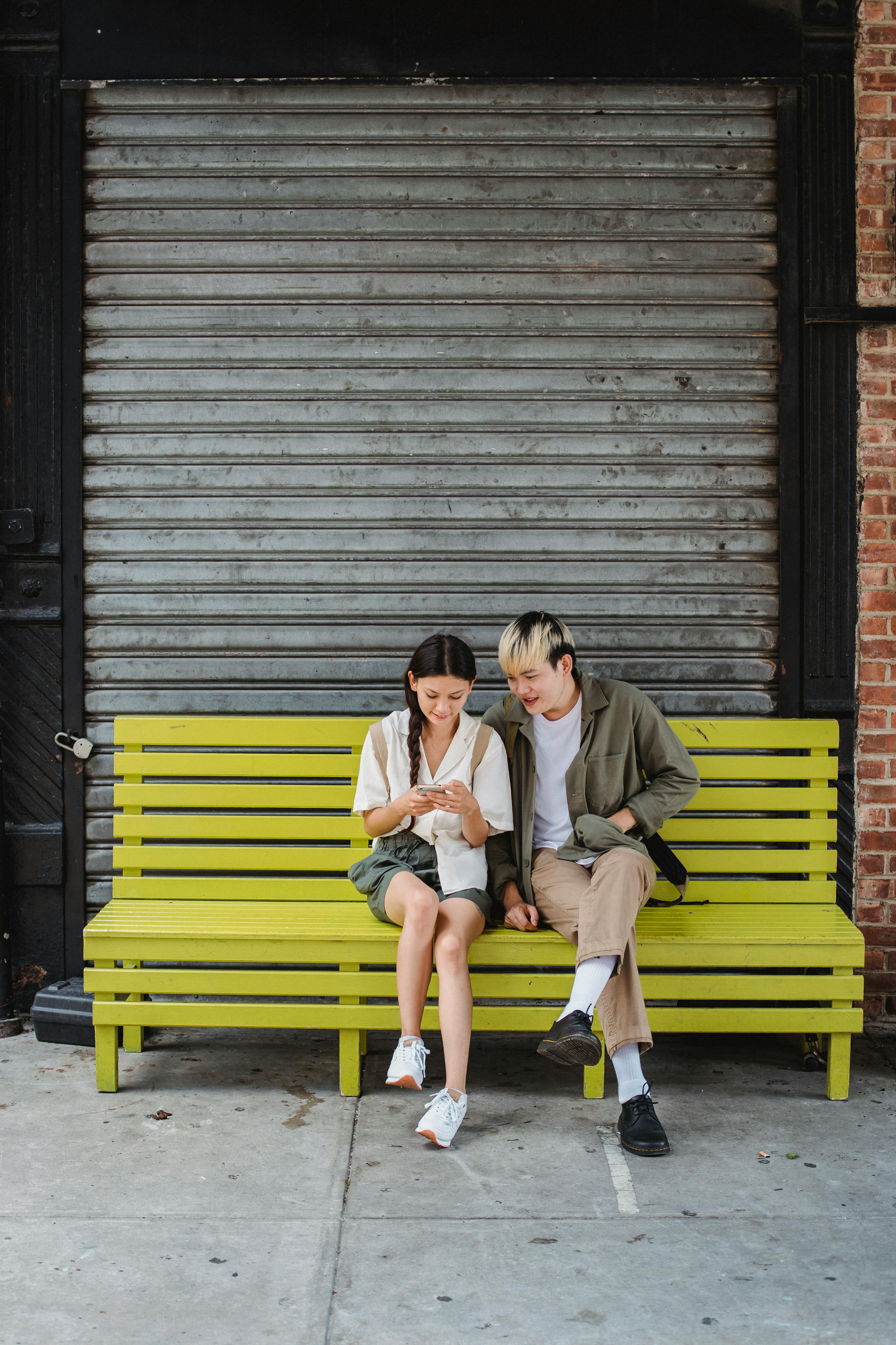 calm couple sitting on bench on street