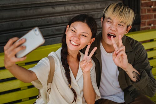 Casal Asiático Alegre Tirando Selfies No Smartphone No Banco Da Rua