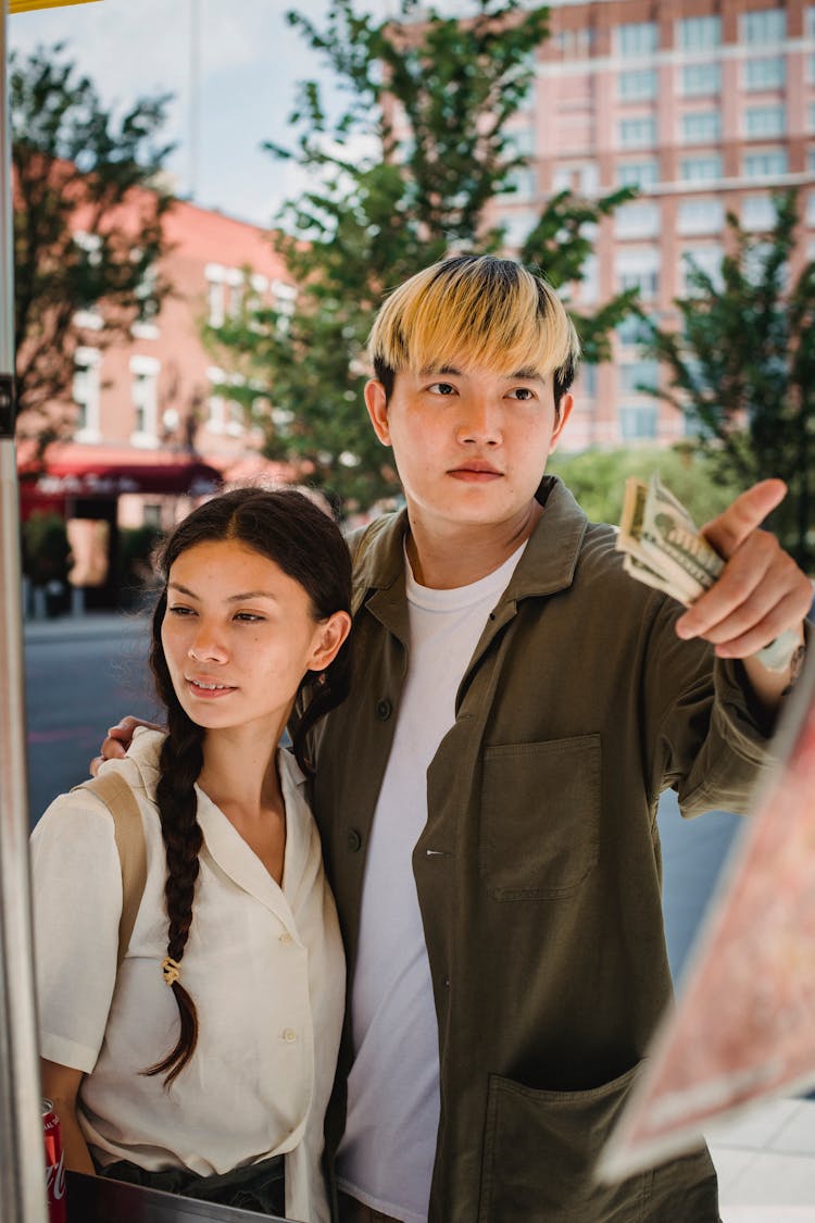 Young Asian Couple Ordering Food In Street Cafe