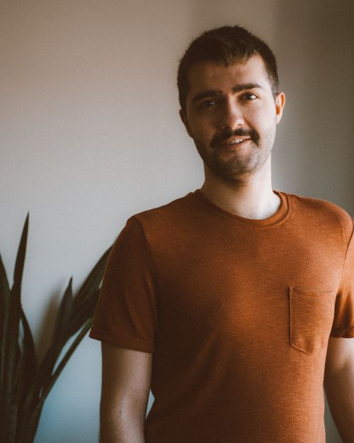 Free Portrait of a smiling man with a beard and moustache in casual wear indoors. Stock Photo