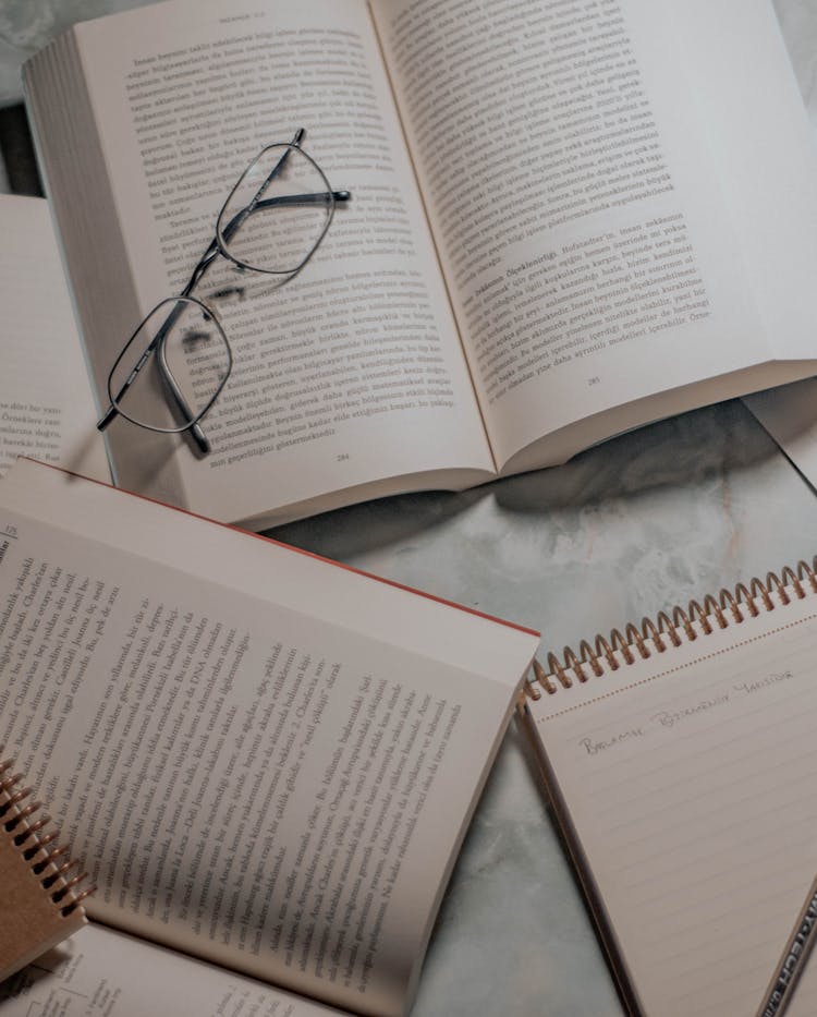 Top View Of Open Books And Glasses On Table