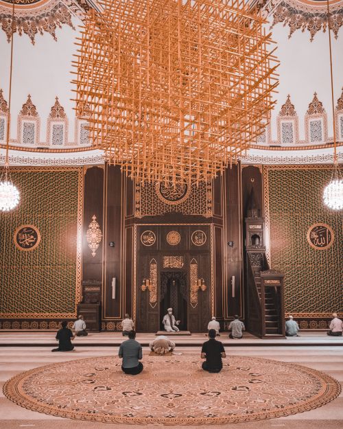 Free People praying inside an ornate mosque with intricate Islamic architecture and design. Stock Photo