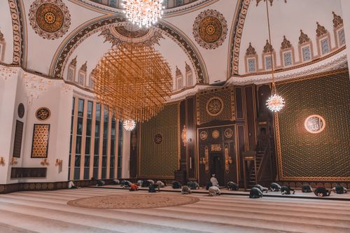 Free Elegant mosque interior with people praying, showcasing intricate Islamic architecture and spirituality. Stock Photo