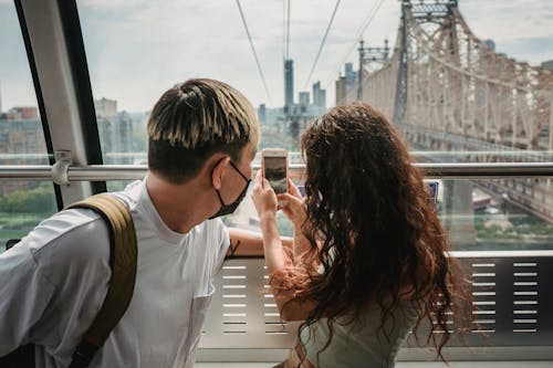 Man taking photo of girlfriend in protective gloves and mask · Free ...