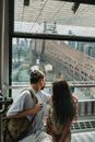 年轻夫妇乘坐缆车，欣赏桥梁和城市景观