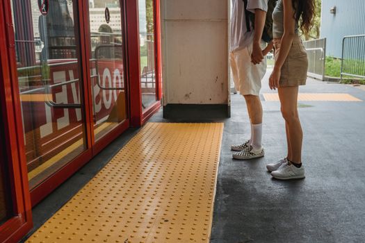 Young couple holding hands while waiting for funicular