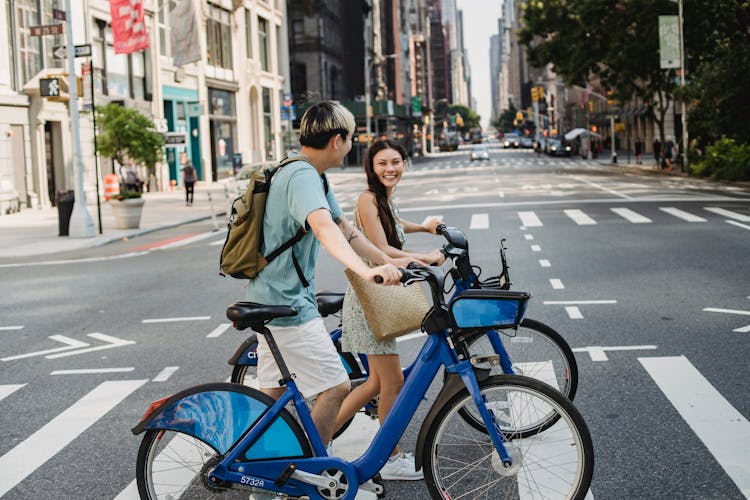 Asian Couple With Bicycles Walking On Crosswalk