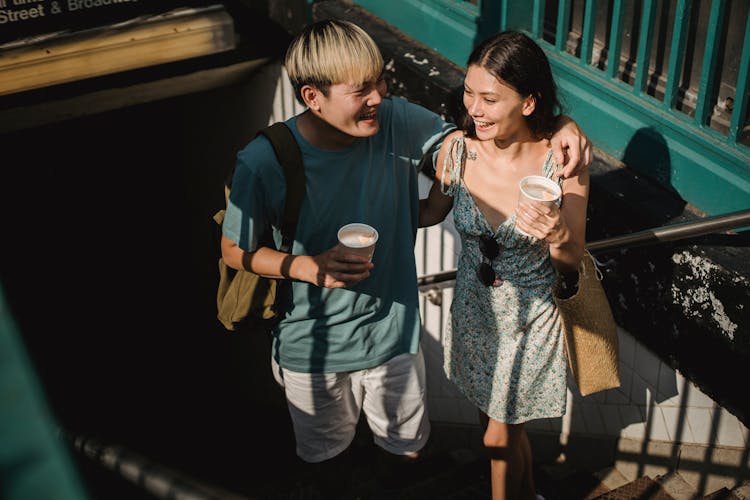 Happy Asian Couple Walking Up Stairs In Metro