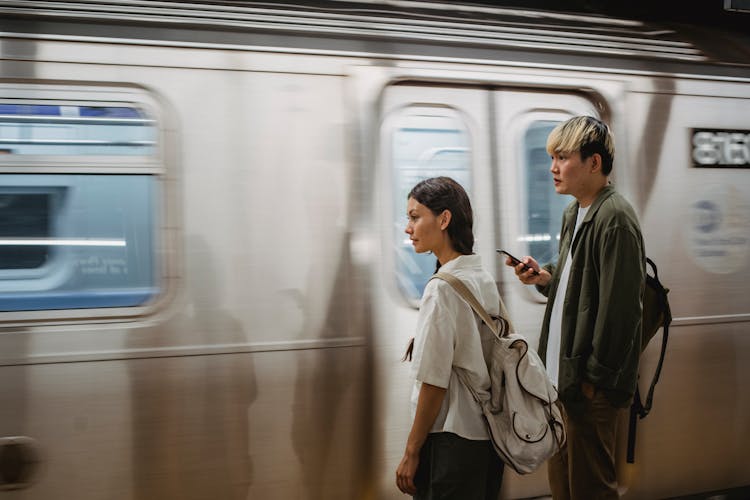 Calm Asian Couple Standing On Train Platform