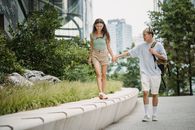 Happy Asian couple walking on street