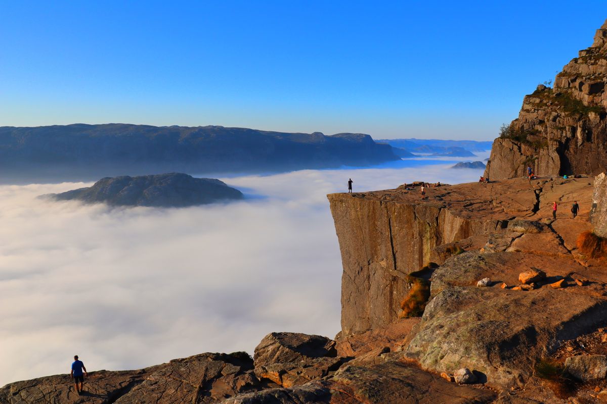Preikestolen cliff with dramatic cloud cover and rocky landscape