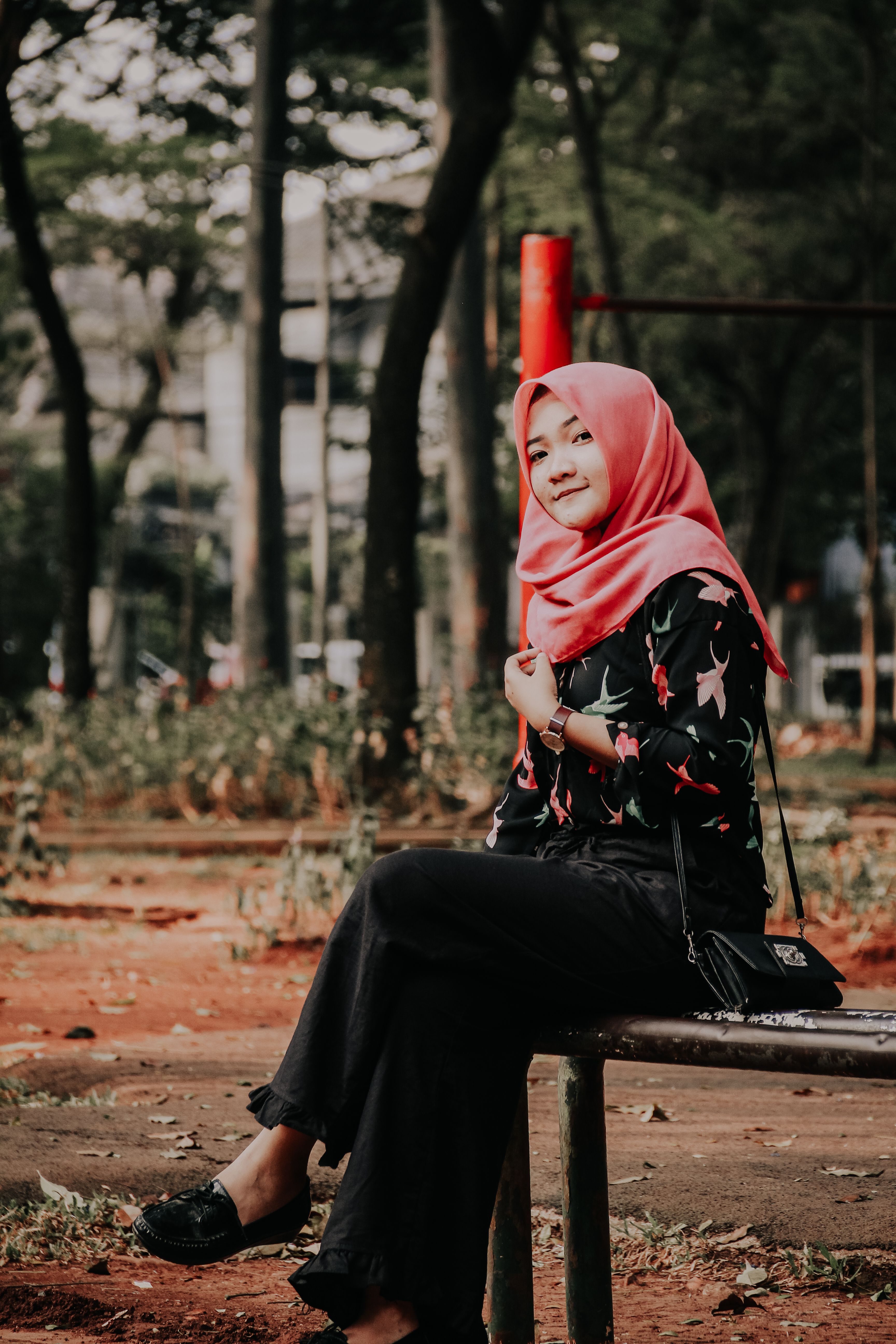 Woman in Hijab Sitting on Brown Wooden Bench · Free Stock Photo