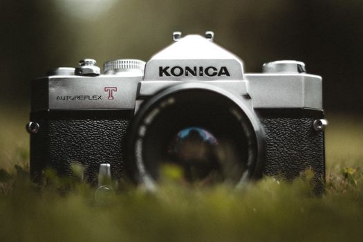 Close-up of a vintage Konica Autoreflex camera in an outdoor setting.