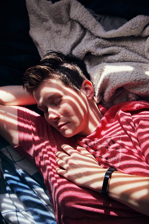 Free Man in Red and White Stripe Polo Shirt Lying on Bed Stock Photo