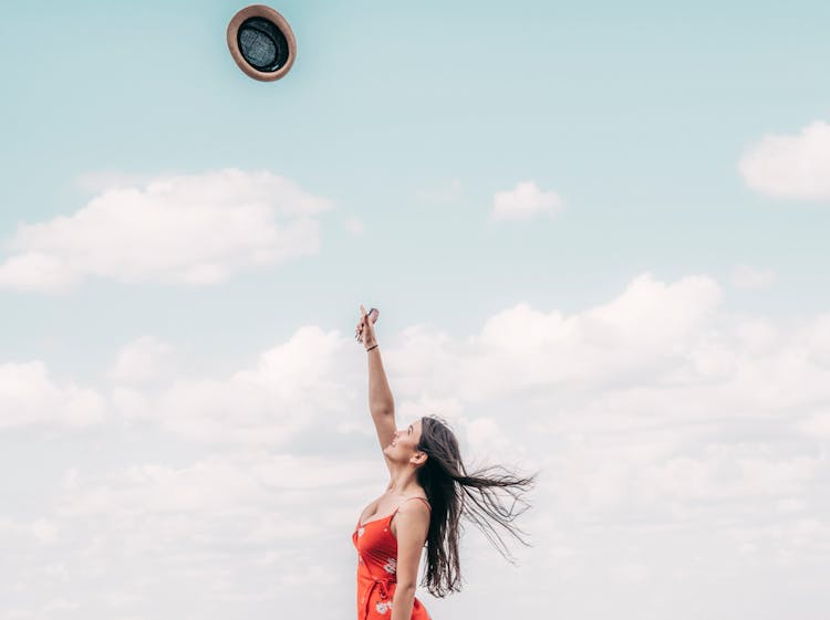 Beautiful Happy Woman Throwing Hat In Air